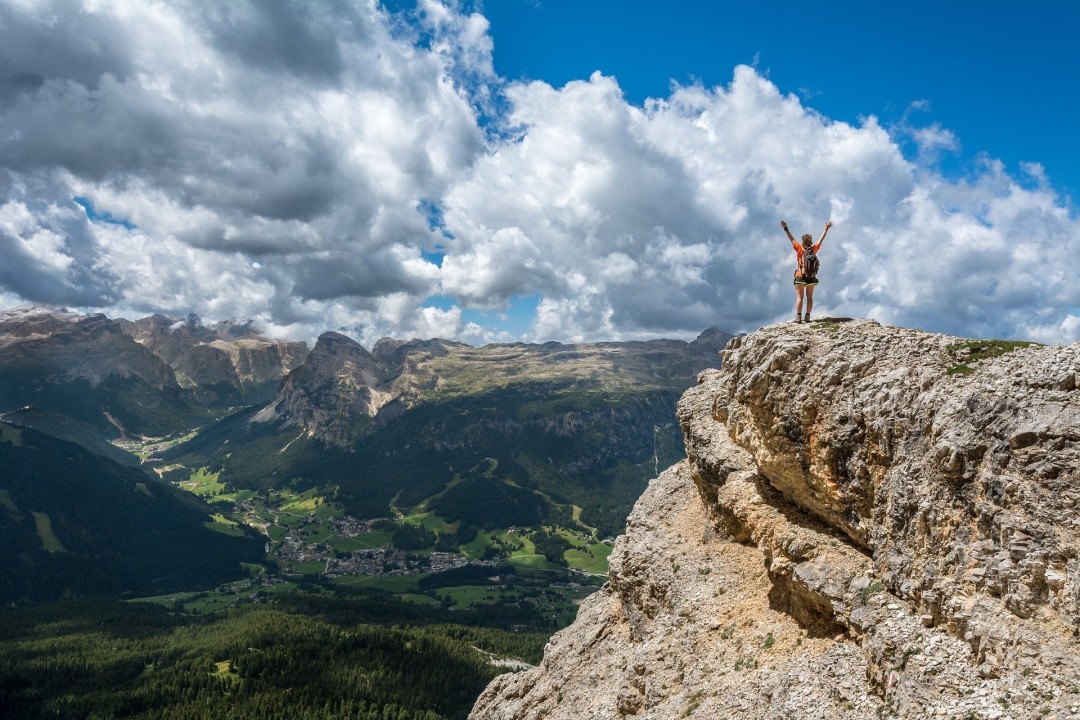 Woman standing on moutain with arms raised