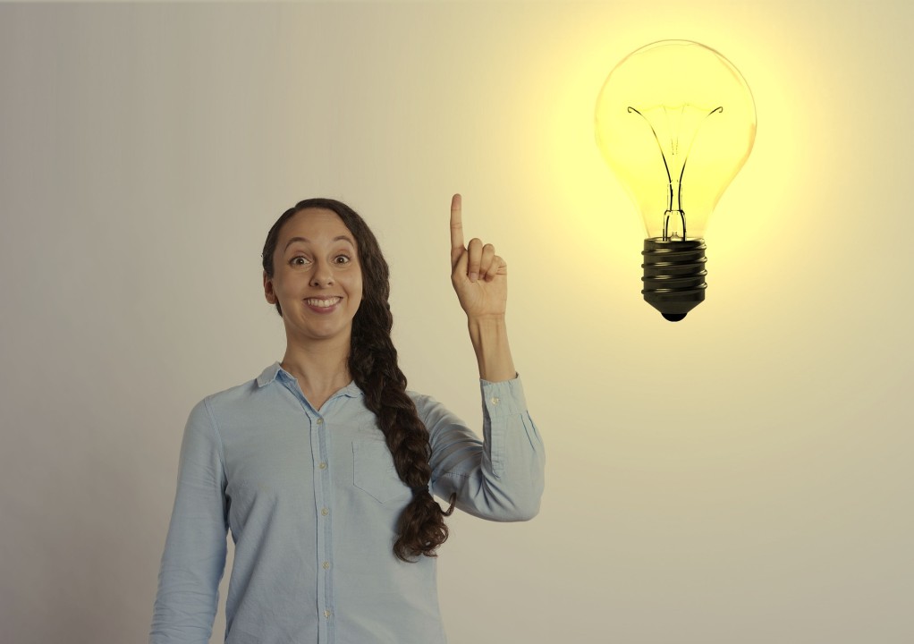 Wome with finger raised and idea light bulb