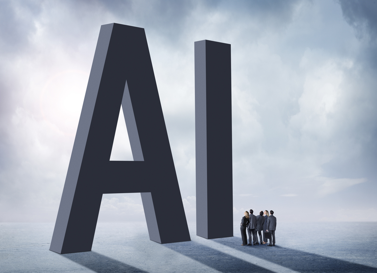 A group of businesspeople stand in the shadow of the large letters, "AI" which stand for artificial intelligence. They are concerned and unsure about the unknown implications of the rollout of artificial intelligence on our society.