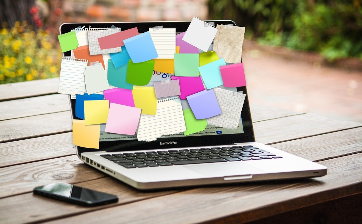 MacBook Pro laptop with sticky notes covering the screen